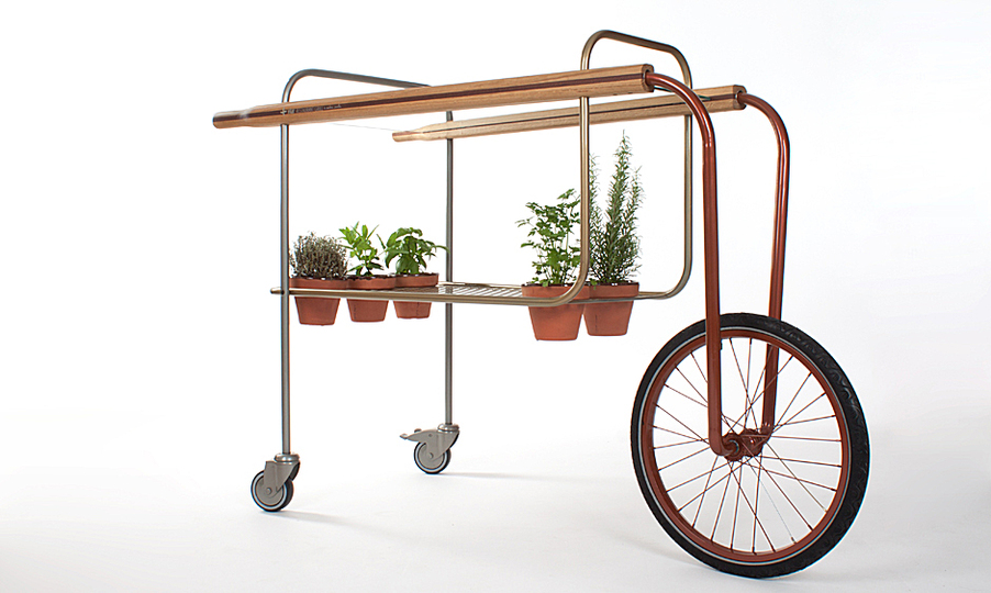 Food Transport: CarRem is a couple of carts designed to hold food, drinks and their seasonings, and belongs to the Retro Sports Furniture collection, together with the Tamborem stool.

The goal is that restaurant’s guests can choose the herb they prefer right from the plant and enjoy its flavour and aroma in the freshest way possible.
 
The cocktail model holds a couple of ice buckets as well as two plant pots for different herbs to enrich a drink, whereas the food model holds five plant pots for different aromatic herbs to complement the dishes.
 
With a minimalistic aesthetic, so it has a minor impact on the ambiance, its glass surface leads to a floating sensation of the elements put above. It also provides big mobility thanks to its wheelbarrow structure, so it can be easily handled in small spaces.
 
Its handlebars are made of antique rowing paddles which provide good stability to the whole cart, and its tubes are painted in medal colors (gold, silver and bronze).
 