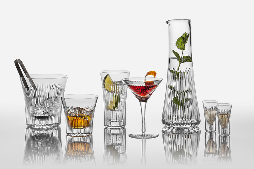 Serve Up!: Lyre Barware. A range of full lead hand-cut crystal contemporary barware that combines modern elegance with an element of classical Greece. Includes a highball glass, shot glass, martini glass and ice bucket to complement its existing water tumbler and carafe. Designer : Katy Holford for Cumbria Crystal. Stand name : CUMBRIA CRYSTAL. Show : scènes d'intérieur