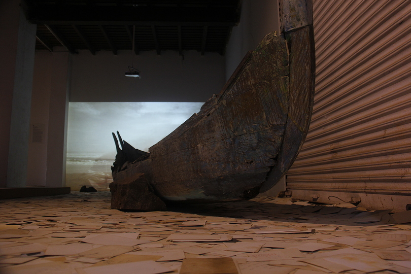 Kochi Biennale 2014: Dinh Q Le's 'Erasure' at Aspinwall House, Fort Kochi. Single-channel video: 2K HD  Colour, sound  7 minutes, found photographs, stone, wooden boat fragments; computer, scanner, dedicated website  Dimensions variable 