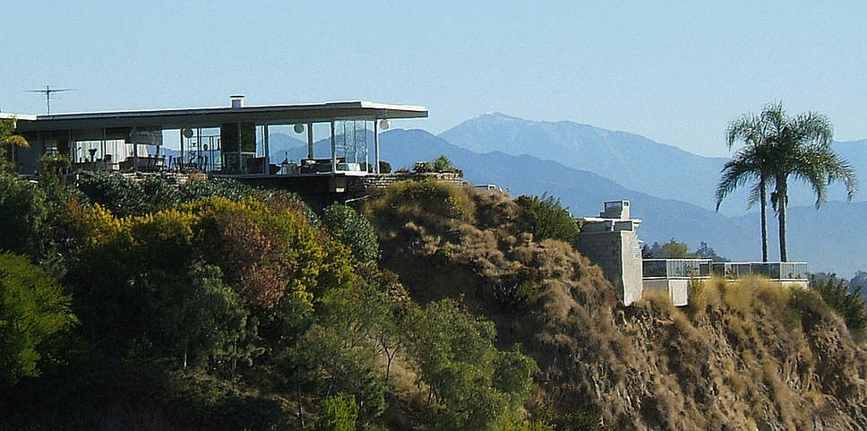 Stahl house: Structure: Steel frame, with exposed ceiling of steel decking. The roof is covered with composition roofing and gravel. Walls are glass and steel decking. Interior walls are faced with insulated wallboard. Steel caissons support the house, on a steep and tricky site.