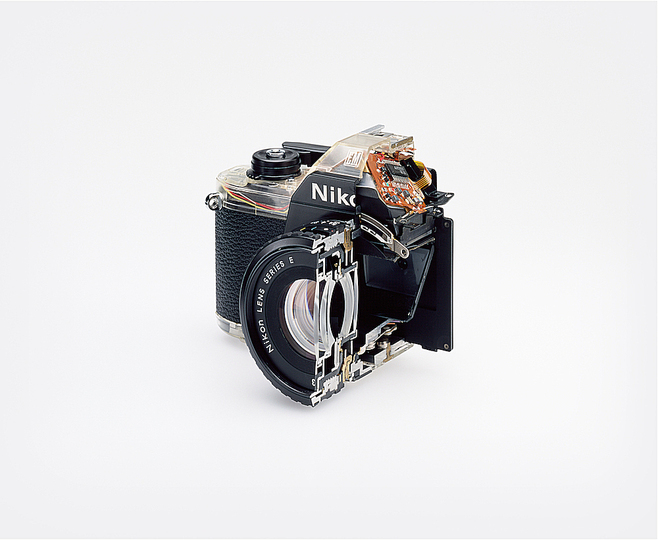 The Production Line of Happiness: Christopher Williams (American, born 1956). Cutaway model Nikon EM. Shutter: / Electronically governed Seiko metal blade shutter vertical travel with speeds from 1/1000 to 1 second with a manual speed of 1/90th. / Meter: Center-weighted Silicon Photo Diode, ASA 25-1600 / EV2-18 (with ASA film and 1.8 lens) / Aperture Priority automatic exposure / Lens Mount: Nikon F mount, AI coupling (and later) only / Flash: Synchronization at 1/90 via hot shoe / Flash automation with Nikon SB-E or SB-10 flash units / Focusing: K type focusing screen, not user interchangeable, with 3mm diagonal split image rangefinder / Batteries: Two PX-76 or equivalent / Dimensions: 5.3 × 3.38 × 2.13 in. (135 × 86 × 54 mm), 16.2 oz (460g) / Photography by the Douglas M. Parker Studio, Glendale, California / September 9, 2007– September 13, 2007. 2008. Chromogenic color print. Paper: 20 x 24″ (50 .8 x 61 cm), framed: 29 15/16 x 37 3/16″ (76 x 94.5 cm). The Museum of Modern Art, New York. Acquired through the generosity of Helen Kornblum in honor of Roxana Marcoci and Committee on Photography Fund. Courtesy of the artist; David Zwirner, New York/London; and Galerie Gisela Capitain, Cologne © Christopher Williams