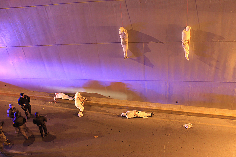 World Press Photo 2014: © Christopher Vanegas, Mexiko, for La Vanguardia / El Guardían. On the early morning on March 3rd, police in northeastern Mexico found 5 dead bodies hanging on the walls of a overpass street. In Mexico, many competing organised criminal drug cartels use such explicit ways as a way of sending [threatening] messages to each other. Since the beginning of the current regime in 2006, at least 60,000 people have fallen victims to drug cartels-related murders.