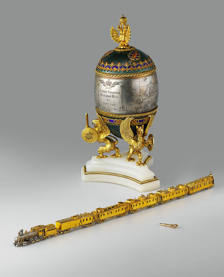 The World of Fabergé: The egg contains a miniature working model of a train of the Trans-Siberian Railway. “Trans-Siberian Railway” Egg. Presented by Emperor Nicholas II to his wife, Alexandra Feodorovna, at Easter 1900 Saint Petersburg, 1900. House of C. Fabergé, Artist: M. Perkhin Gold, platinum, partly-gilt silver, rose-cut diamonds, ruby, onyx, crystal glass, wood, silk, velvet, enamel on guilloché ground, filigree enamel, egg: h. 26 cm, train: l. 39,8 cm, wagon: h. 2,6 cm © The Moscow Kremlin State Historical and Cultural Museum and Heritage Site.